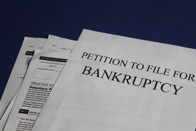 Petition to file for bankruptcy papers spread across a blue surface