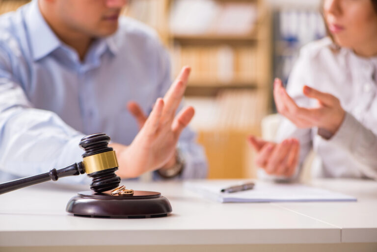 gavel on table with couple having discussion in background