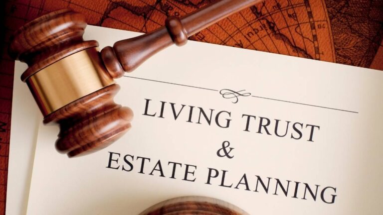 Living trust and estate planning paperwork sitting on an orange map with a judges mallet on top of it