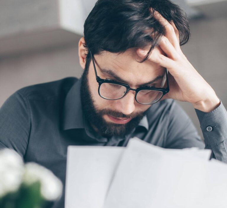 Man looking at his bank statements unhappy