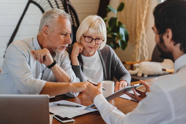 Financial advisor explaining paperwork to elderly retired couple front of desk, can i be the trustee of my trust