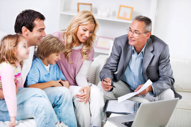 Adults with kids sitting in the living room and talking to the Insurance Agent.