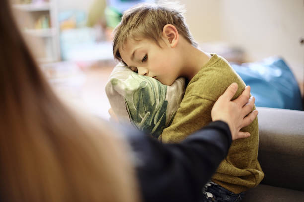 Autism, bullying and hand of mother with boy hugging pillow for comfort, compassion and empathy at home. Disability, abuse and mom with sad child suffering depression, adhd or mental health problem