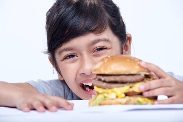 Hungry Little girl enjoying hamburger fast food