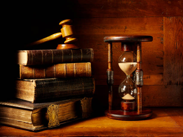 Hourglass with a stack of antique hardback books and a magnifying glass with a gavel and mallet on a wooden desk.Click on the links below to see more of my time, law, book and business images.