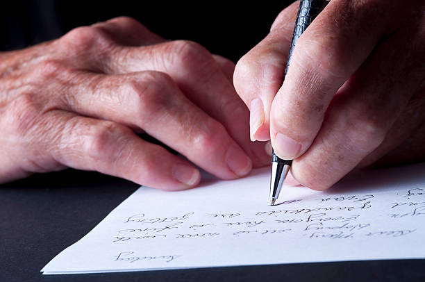 Selective-focus image of Arthritic/Senior Adult Hands writing a letter