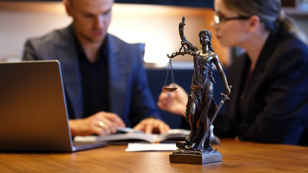 A lawyer meets with a new client. A young male lawyer in a suit sits at an office desk, shares legal advice, explains the inheritance process, tries to help. Legal advice concept