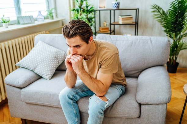 Young worried man feeling bad at home