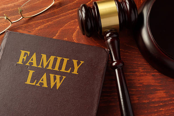 A family law book lies on a wooden desk next to a judge's gavel and a pair of eyeglasses, essential tools for pro bono divorce lawyers.