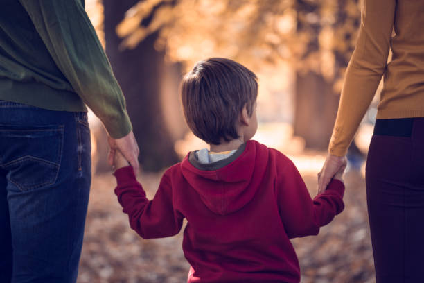 Young family walking through leaves in nature