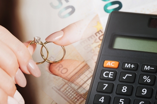 Wedding rings on money. Cost of wedding. Price of getting married background. Golden jewelry on banknote. Cash for getting divorced. Expensive marriage. Fifty euro note. Engagement money.