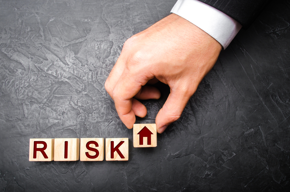 Risk blocks stacked near a small house, illustrating how judgment liens affect Texas family property and estates.