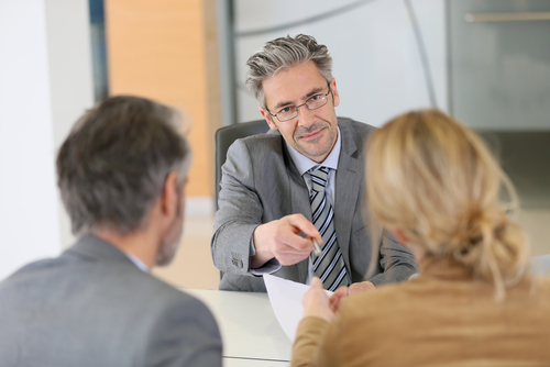 Mature couple signing contract in lawyer's office