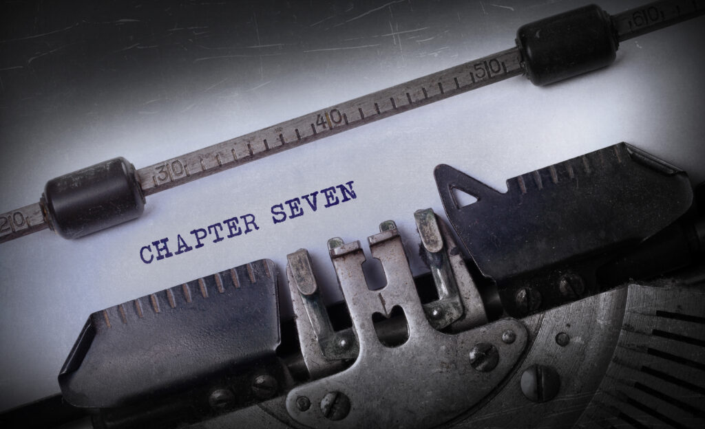 A close-up of a typewriter with the text "CHAPTER SEVEN" typed on a sheet of paper.