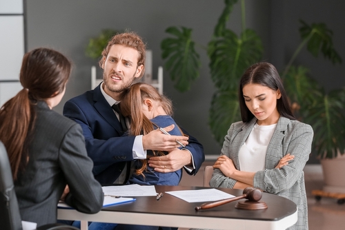 Young couple and their daughter visiting divorce lawyer in office