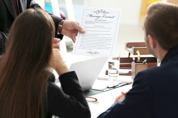 A businessman is holding a document in front of a group.