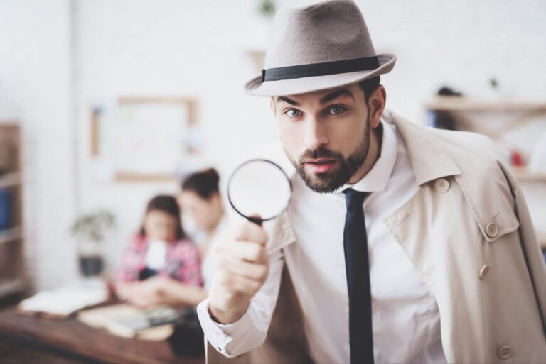 Man in a detective costume, hire a Private Investigator, holding a magnifying glass.