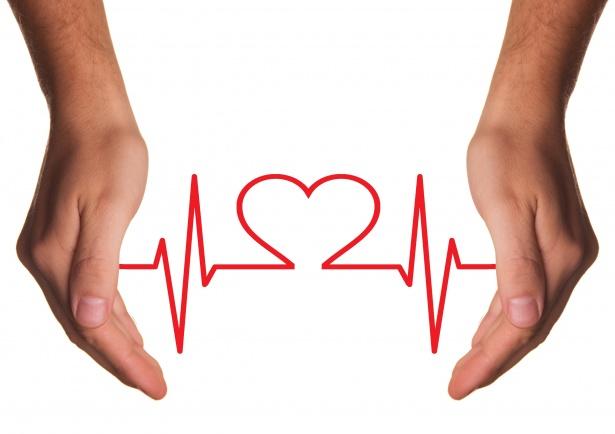 Two hands are open, with palms facing each other, surrounding a red heart symbol integrated into a heartbeat line on a white background, symbolizing the importance of health info sharing.