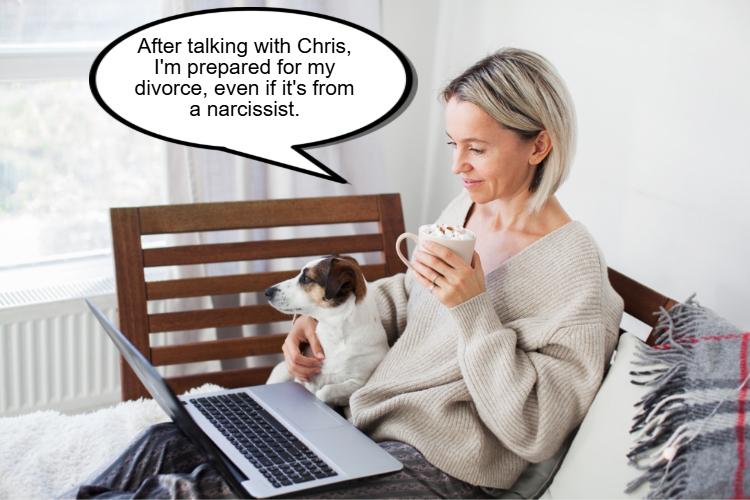 A woman sits on a bed with a dog, holding a mug and looking at a laptop. 